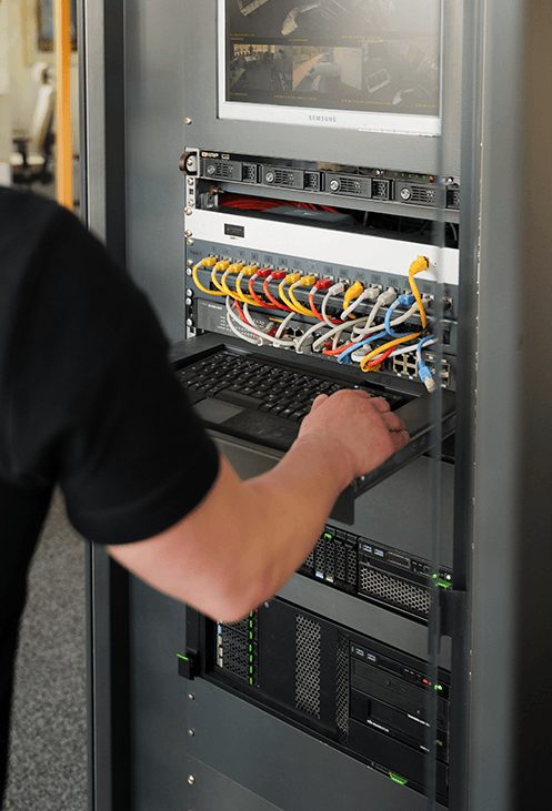 Techniker der triPlus Systemhaus GmbH bei der Arbeit an einem Serverschrank – Wartung und Betreuung moderner IT-Systeme.